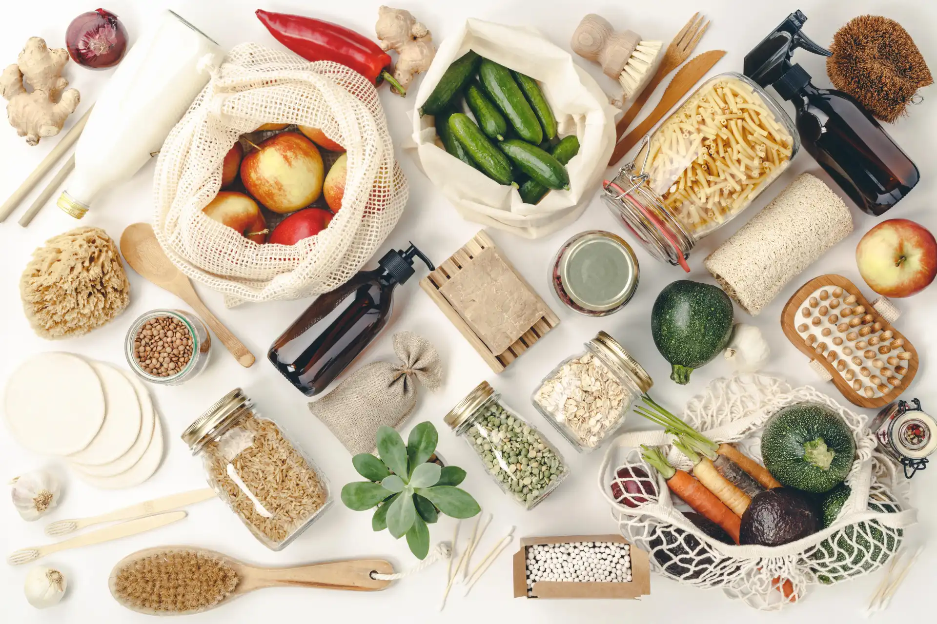 Cuisine zéro déchet, vue de dessus : produits en vrac dans des bocaux et sacs en filet, fruits et légumes non emballés, accessoires naturels